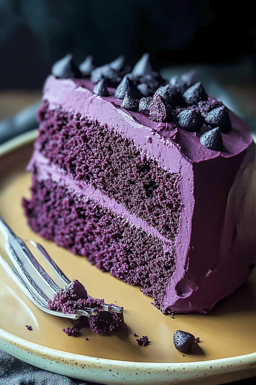 Purple velvet cake slice on plate showing perfect texture and swirl pattern